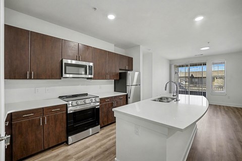 A modern kitchen with dark wood cabinets and white countertops.