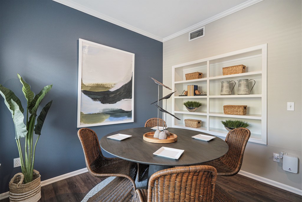 A dining room with a round table and chairs.