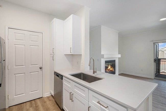 A kitchen with white cabinets and a stainless steel refrigerator.