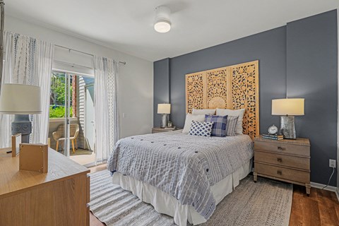 A bedroom with a bed, nightstands, and a window with curtains.