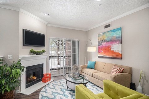 A living room with a fireplace, a couch, a coffee table, and a painting on the wall.