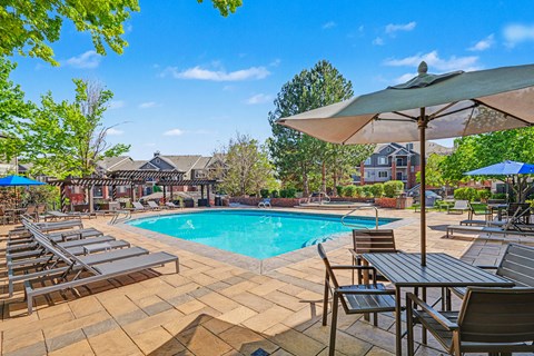 A pool surrounded by chairs and umbrellas.