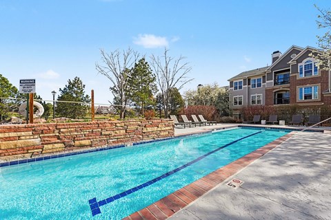 A swimming pool with a warning sign in front of a house.