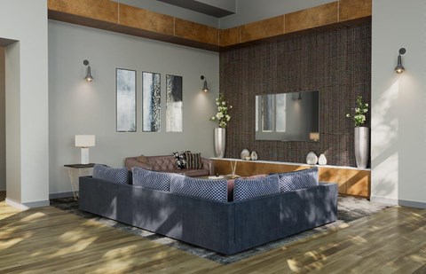 A modern living room with a grey sofa and a wooden floor.