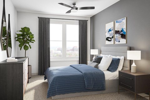 A bedroom with a bed, nightstand, and a plant.