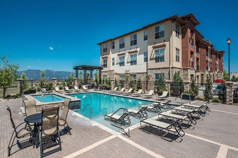 A large building with a pool in front of it.