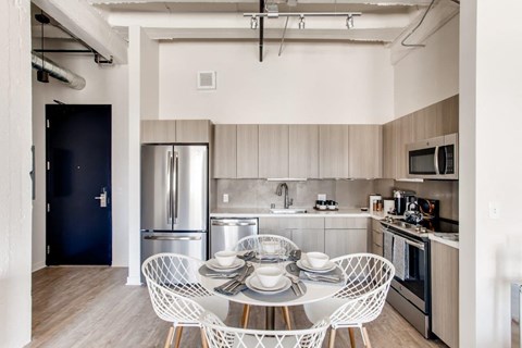 A modern kitchen with a dining table set for two.