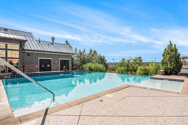 A swimming pool with a slide and a building in the background.