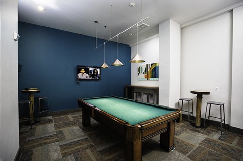 A pool table in a room with a blue wall.