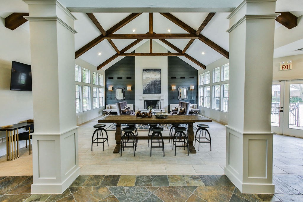 Community lounge seating area with fireplace and stools  at The Villages of Briar Forest, Houston, Texas
