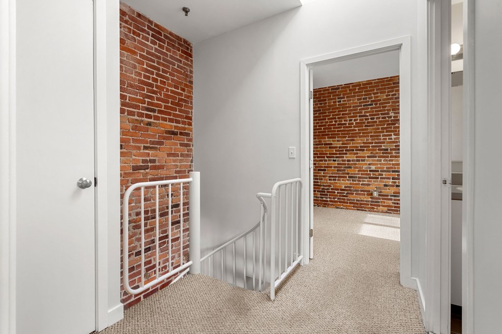 A room with a white door and a white railing.