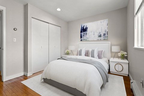 a white bedroom with a large bed and a window