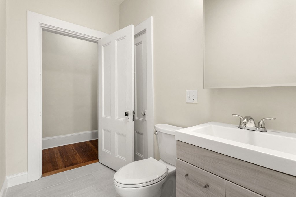 a bathroom with a toilet sink and a mirror