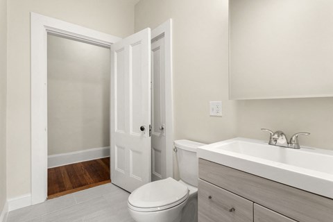 a bathroom with a toilet sink and a mirror