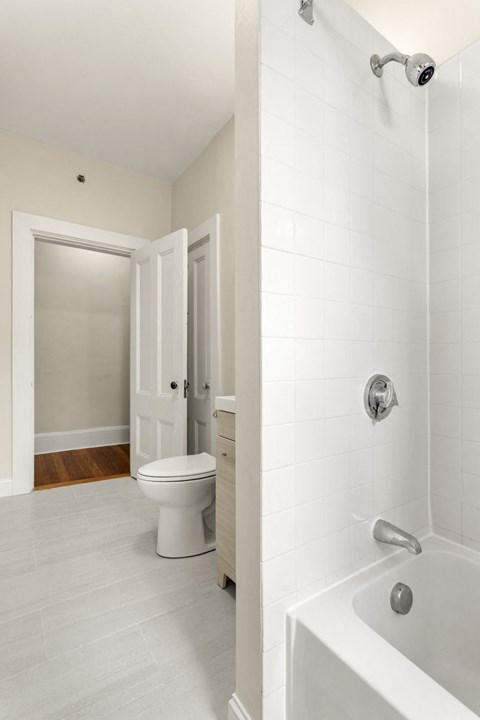 a white bathroom with a tub and a toilet