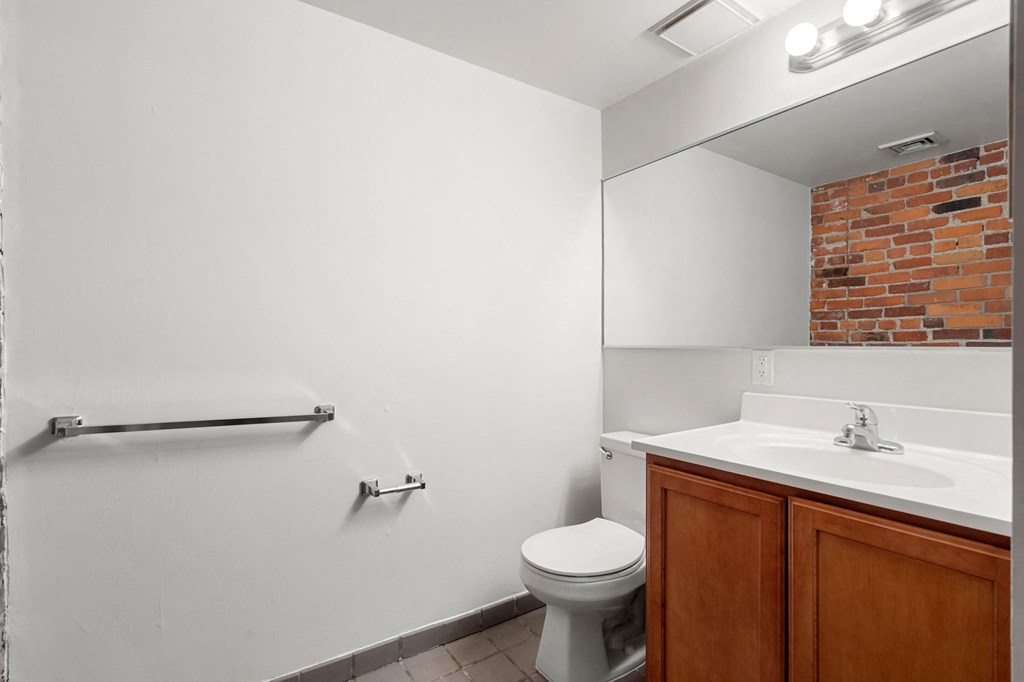 A white toilet sits in a bathroom next to a white sink.