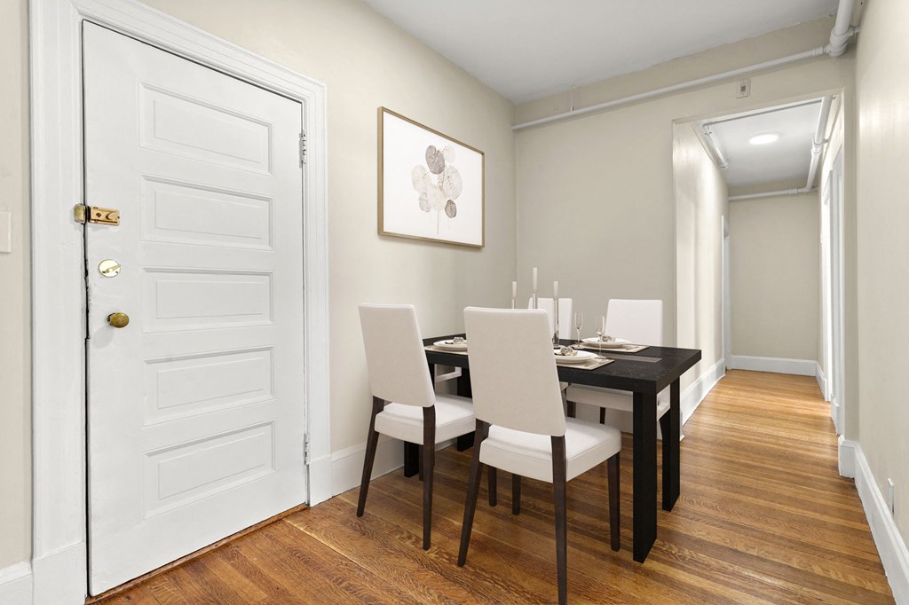a dining room with a table and chairs and a white door