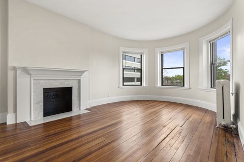 a living room with a fireplace and wood floors