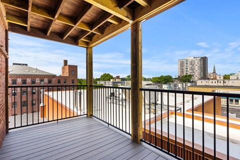 440-7 a balcony with wood floors and a view of the city