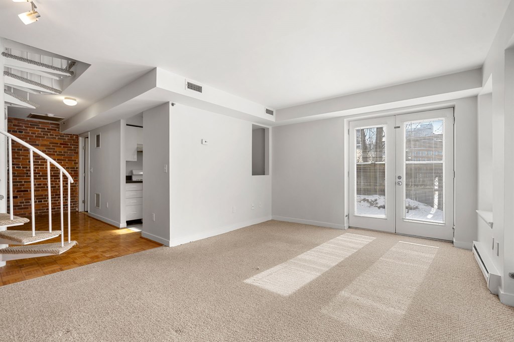 A room with a white door and a carpet on the floor.