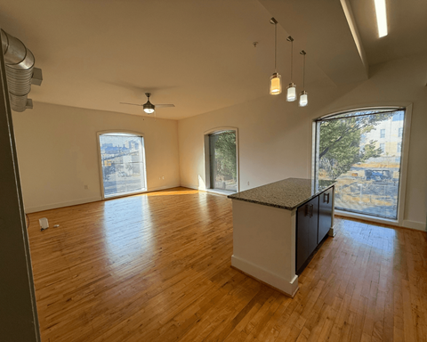 A room with wooden floors and a kitchen island.