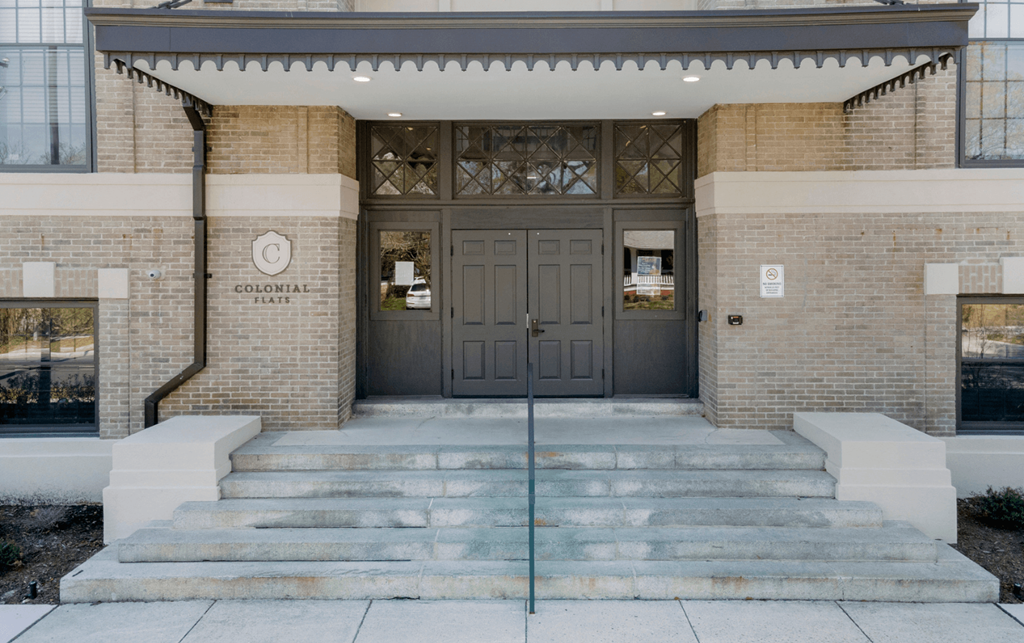 the front of a building with stairs and a double door