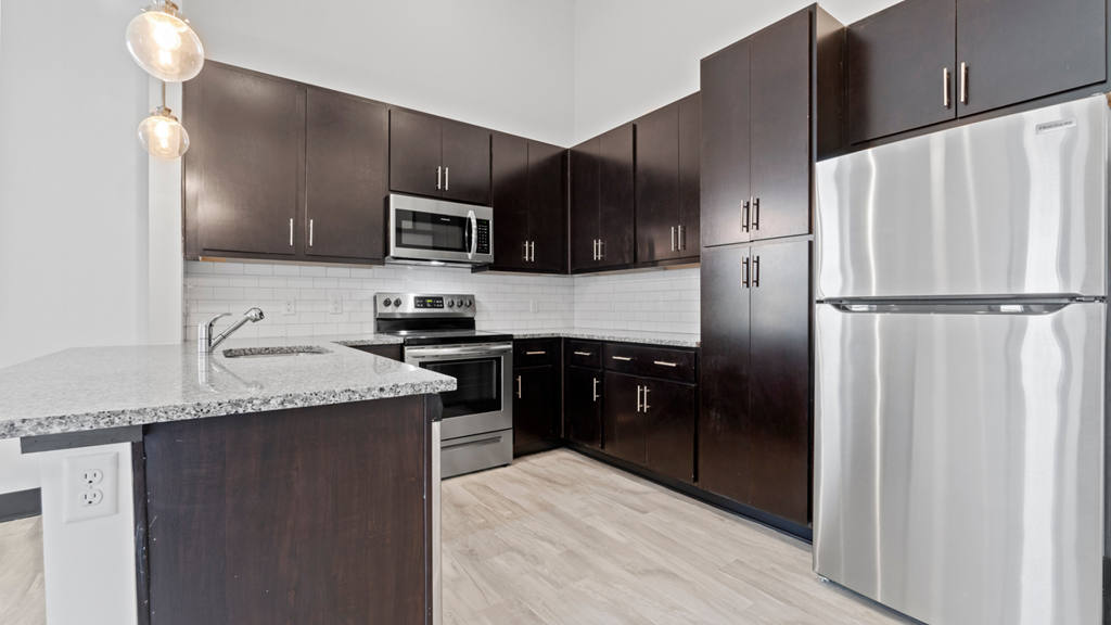 a kitchen with stainless steel appliances and dark wood cabinets