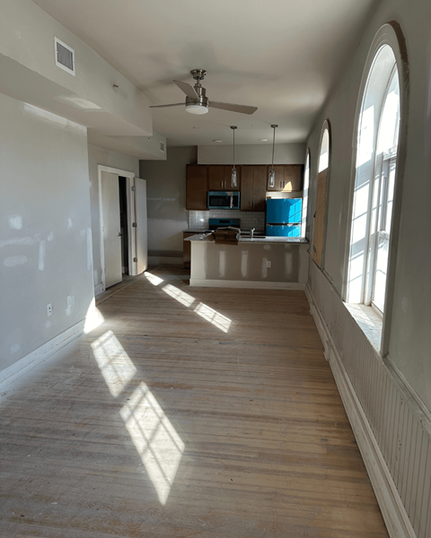 a view of a empty living room and kitchen in a house