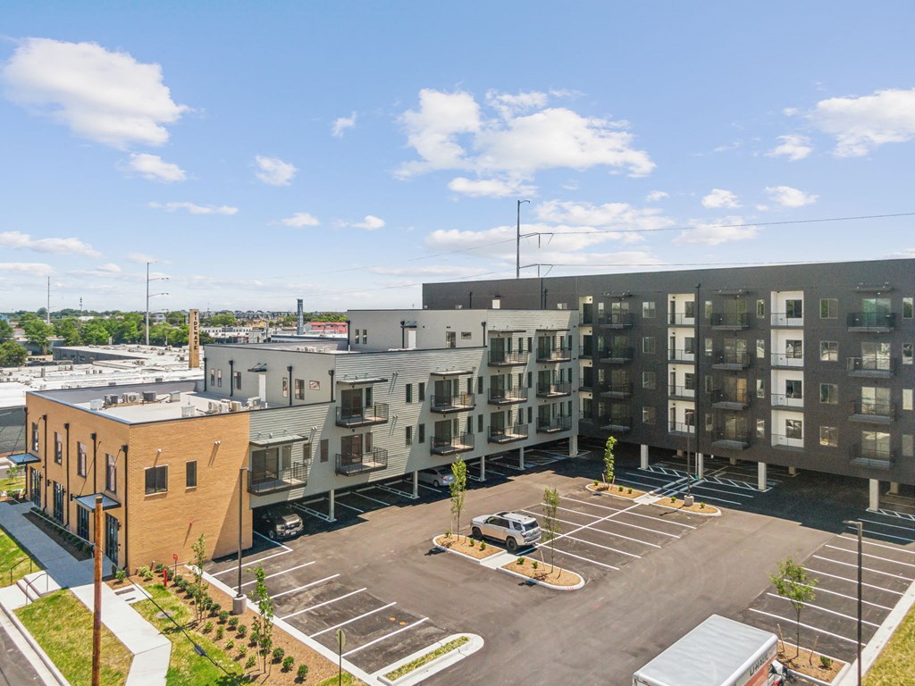 an overhead view of an apartment complex with a parking lot