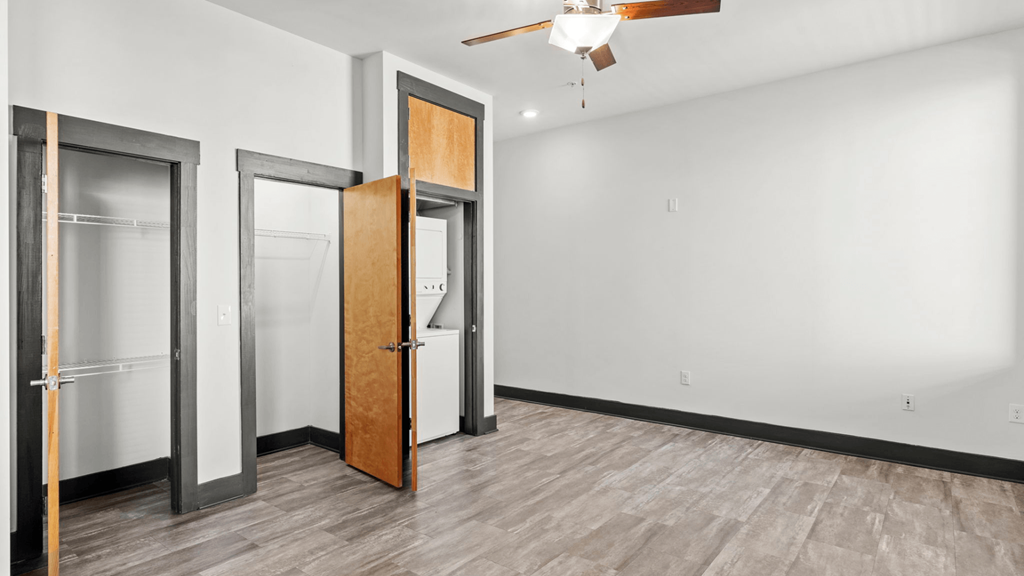 a empty room with three doors and a ceiling fan