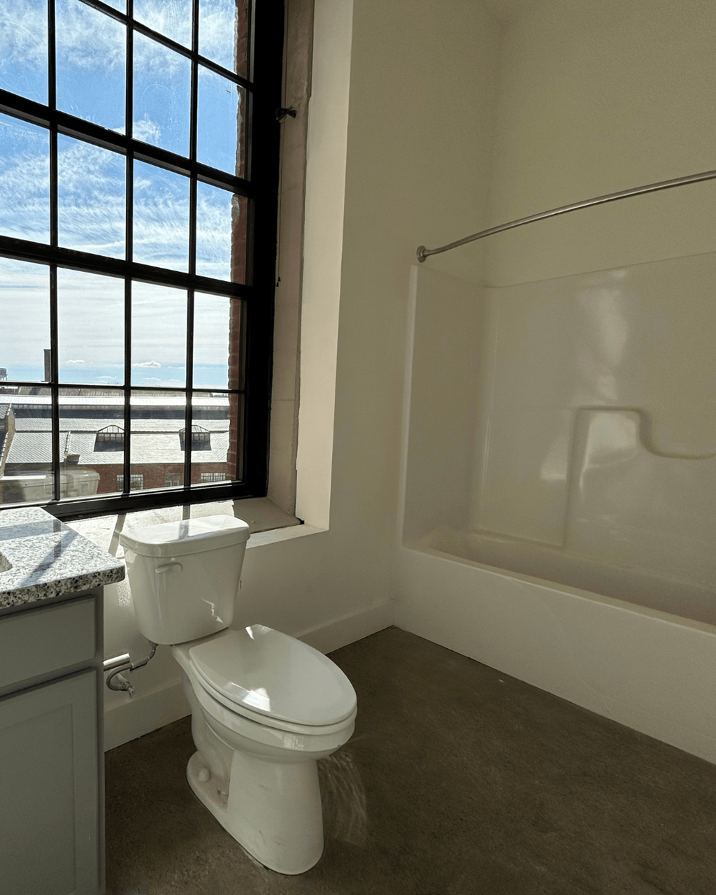 an empty bathroom with a toilet and a window