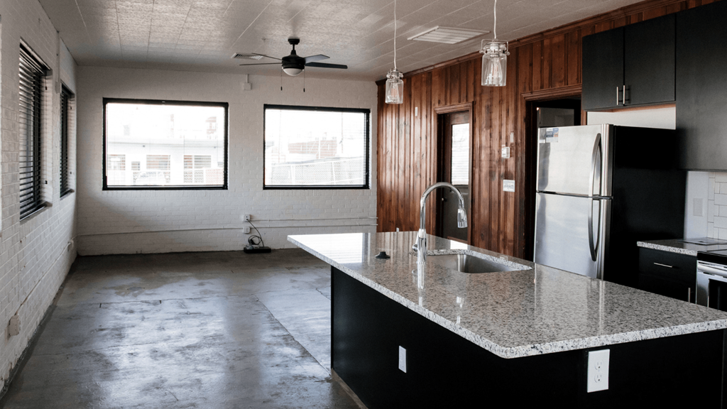 an empty kitchen with a granite counter top and a sink