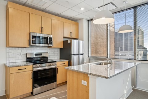 A kitchen with wooden cabinets and a granite countertop.