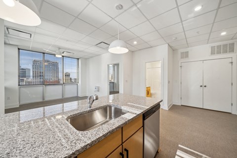 A kitchen with a granite countertop and stainless steel appliances.