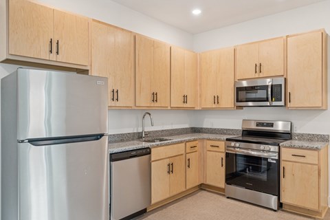 A kitchen with wooden cabinets and stainless steel appliances.