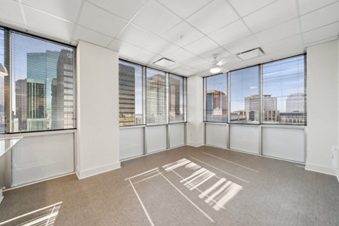 A spacious room with large windows overlooking a cityscape.