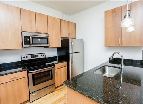 A kitchen with wooden cabinets and granite countertops.