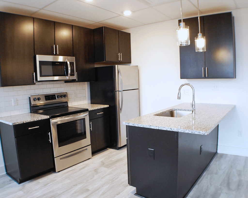 A kitchen with black cabinets and stainless steel appliances.