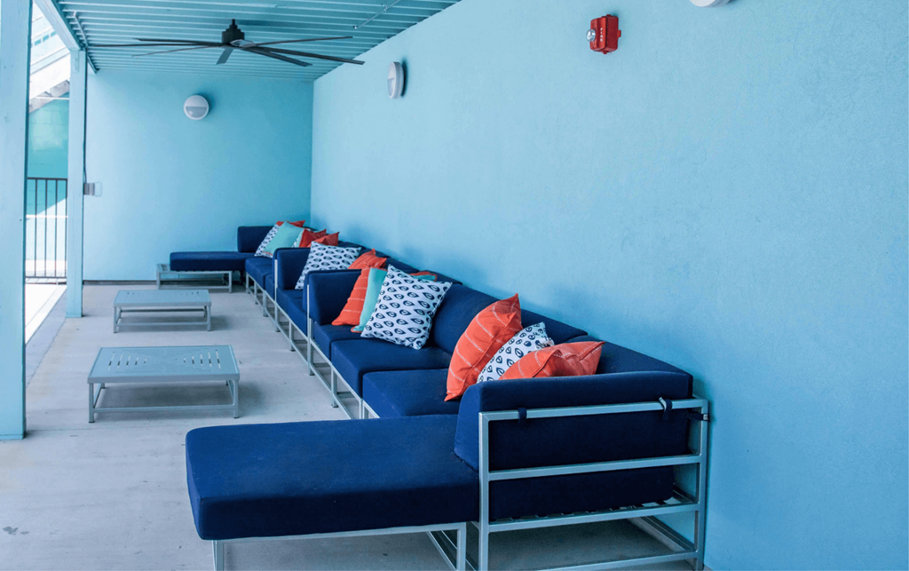a room with blue couches and pillows and a table