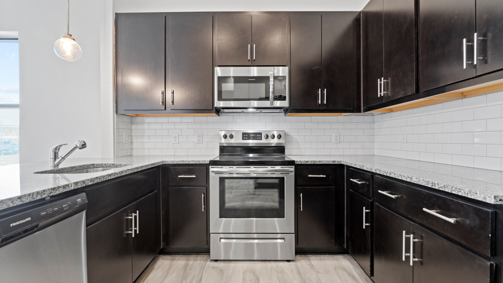 a kitchen with black cabinets and stainless steel appliances