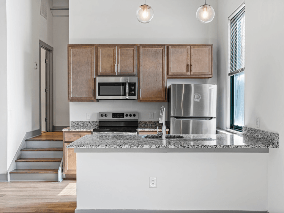 a kitchen with granite counter tops and a stainless steel refrigerator