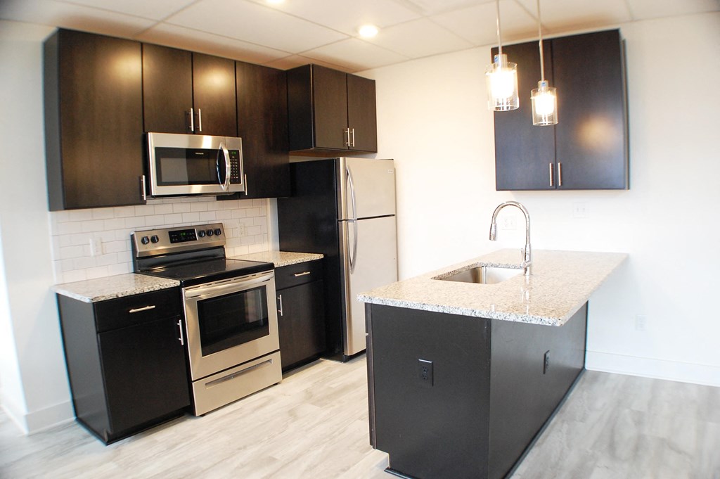 a kitchen with stainless steel appliances and black and white cabinets