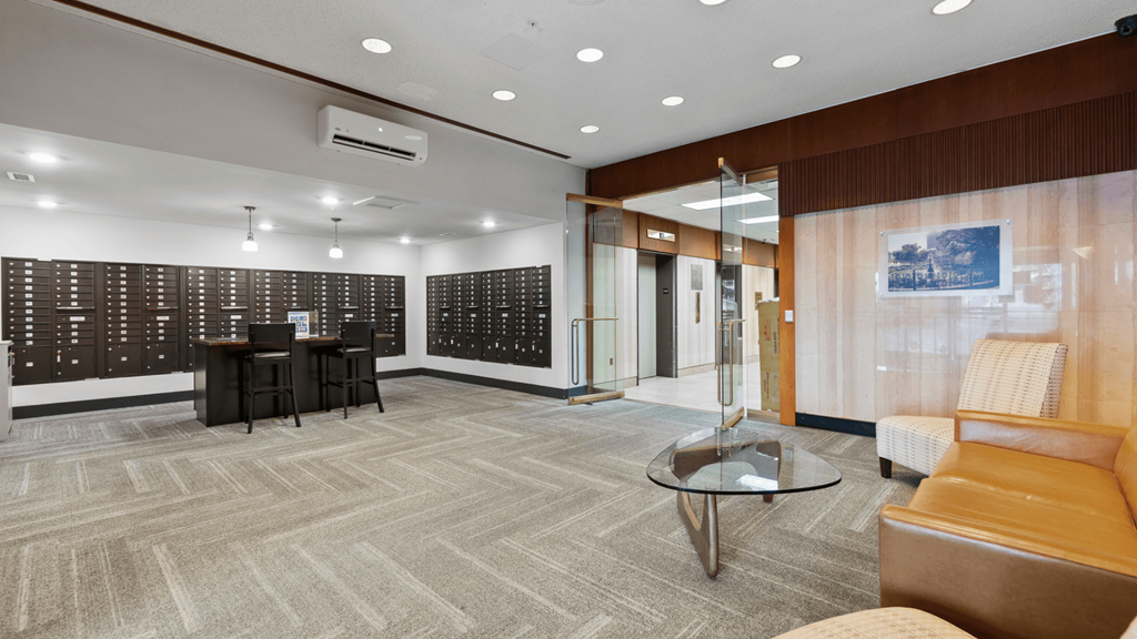 a lobby with chairs and a table in front of a wall of wine racks