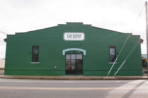 A green building with a sign that says The Depot.