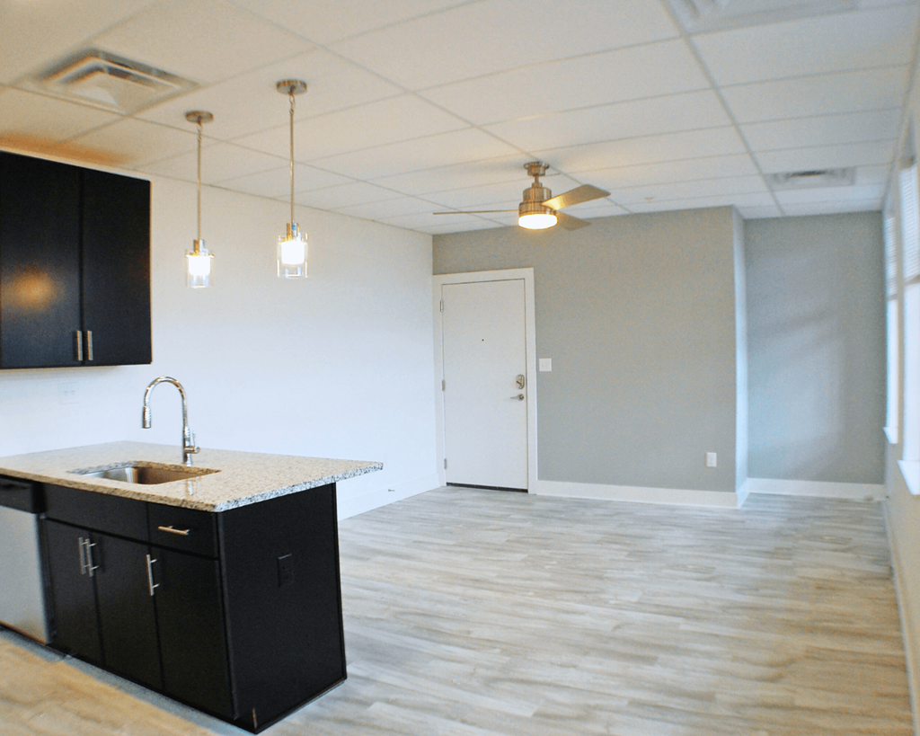 A kitchen with black cabinets and a sink.