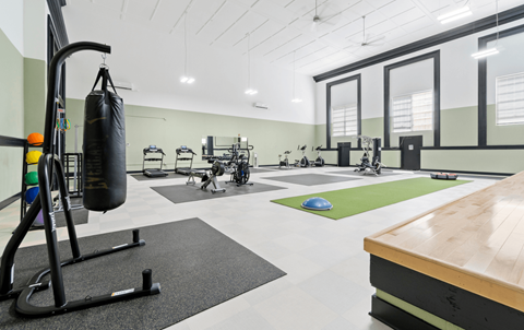 a gym with a punching bag and weights on the floor