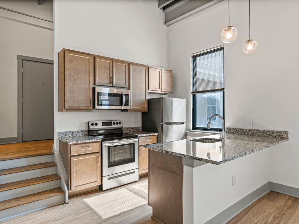 a kitchen with granite counter tops and wooden cabinets