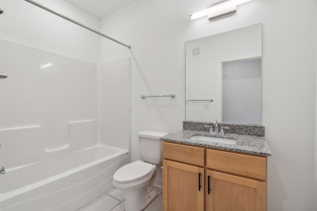 a bathroom with a sink toilet and shower and a mirror
