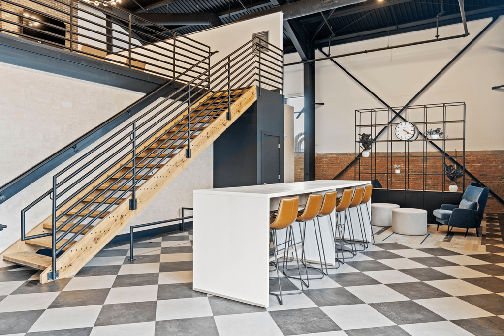 a bar and staircase in a room with a checkered floor