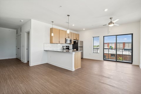 a living room with a kitchen and a large window